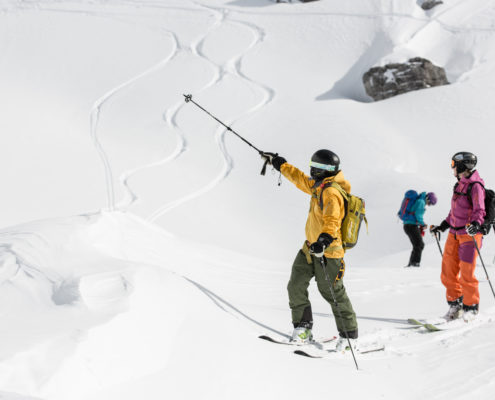 Off-piste ski guide with guest skiers in snow