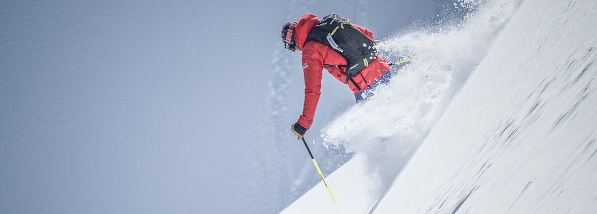 Skier in deep powder snow with mountain peaks in Lech Zürs St. Anton Arlberg